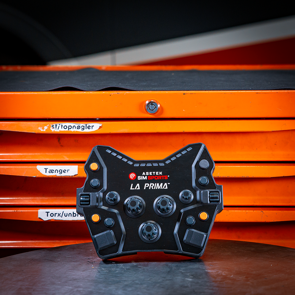 Asetek Simsports La Prima Button Box on a workbench with orange tool drawers in the background.